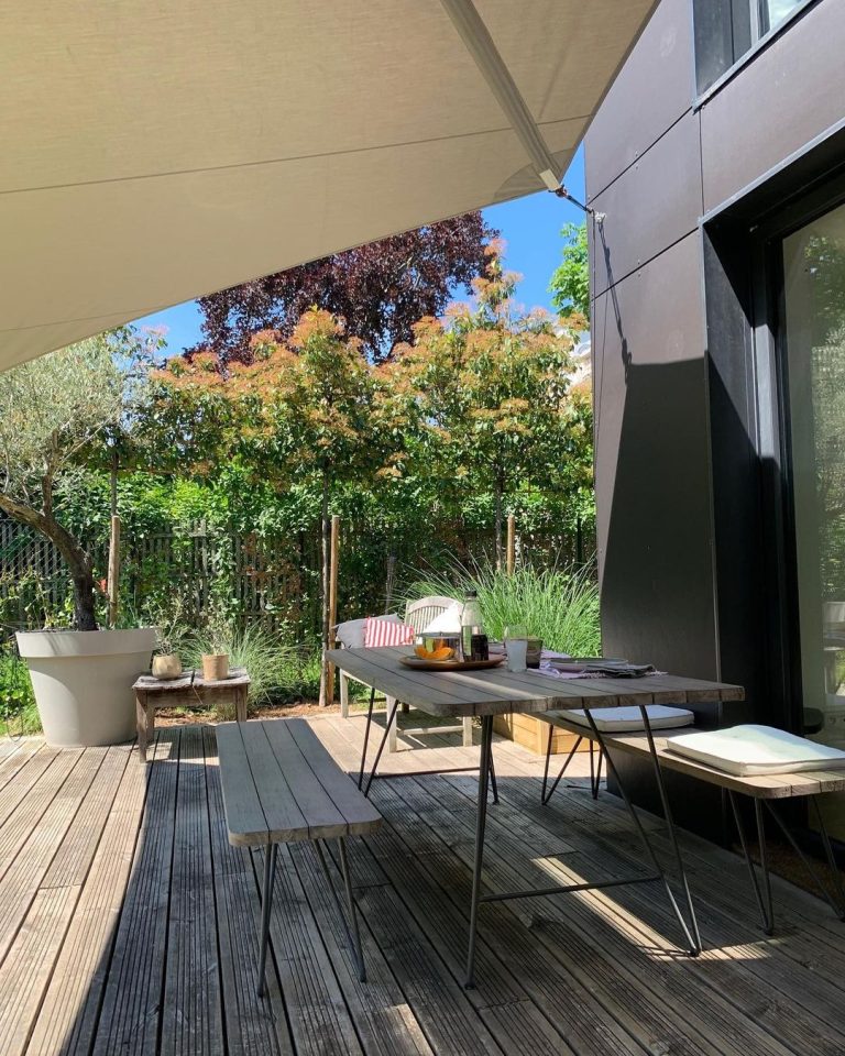 Table pour manger sous une voile d'ombrage enroulable et déperlante