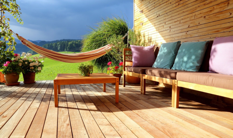 Terrasse en bois décorée et aménagée avec une toile ombrage enroulable
