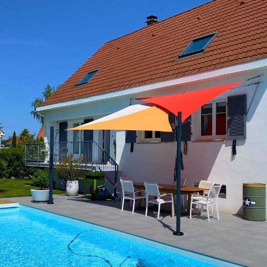 Voiles ombrage triangulaires imperméables avec piquets noirs près d'une piscine pour la deco terrasse exterieur