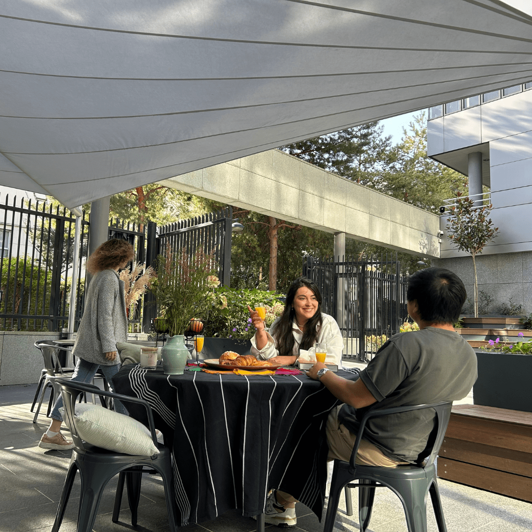 Collaborateurs profitant d'un repas sous une toile d'ombrage sur leur lieu de travail