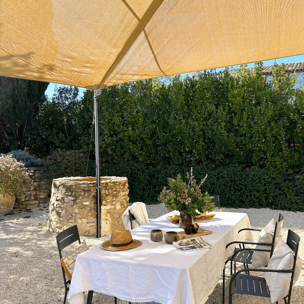 Voile ombrage ajourée avec enrouleur manuel de coloris sable pour ombrager une table à manger