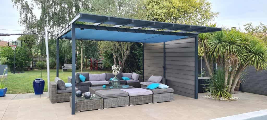 Toile pour pergola sur mesure ajourée bleue ombrageant un salon de jardin