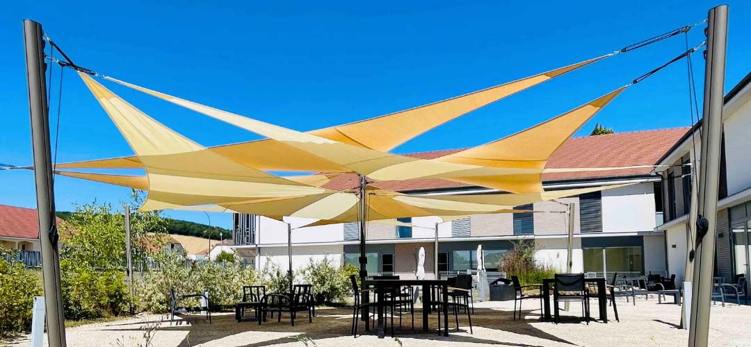 Cream and sand triangular shade sails hung on poles