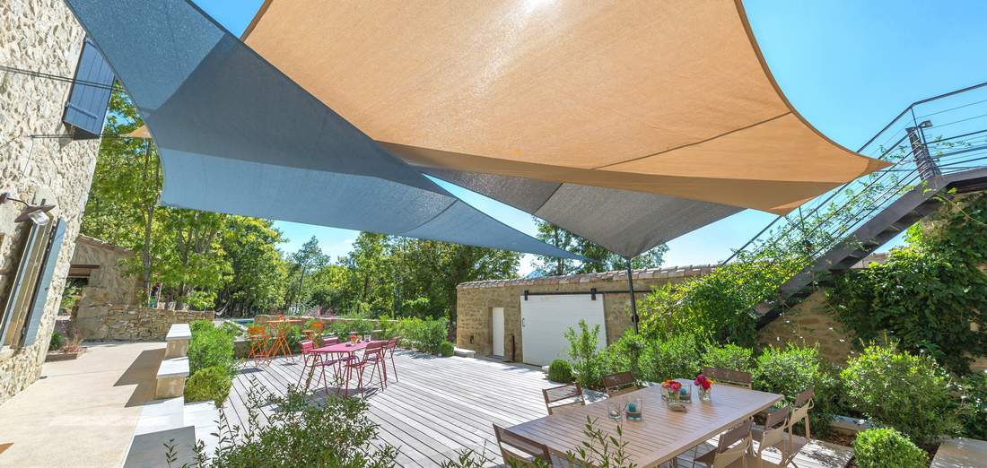 Overlapping triangular and rectangular openwork shade sails for a designer outdoor space