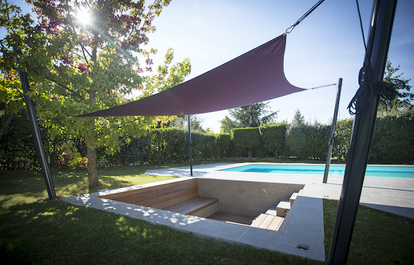 une voile d ombrage fixée sur 4 mats pour toile ombrage près d'une piscine